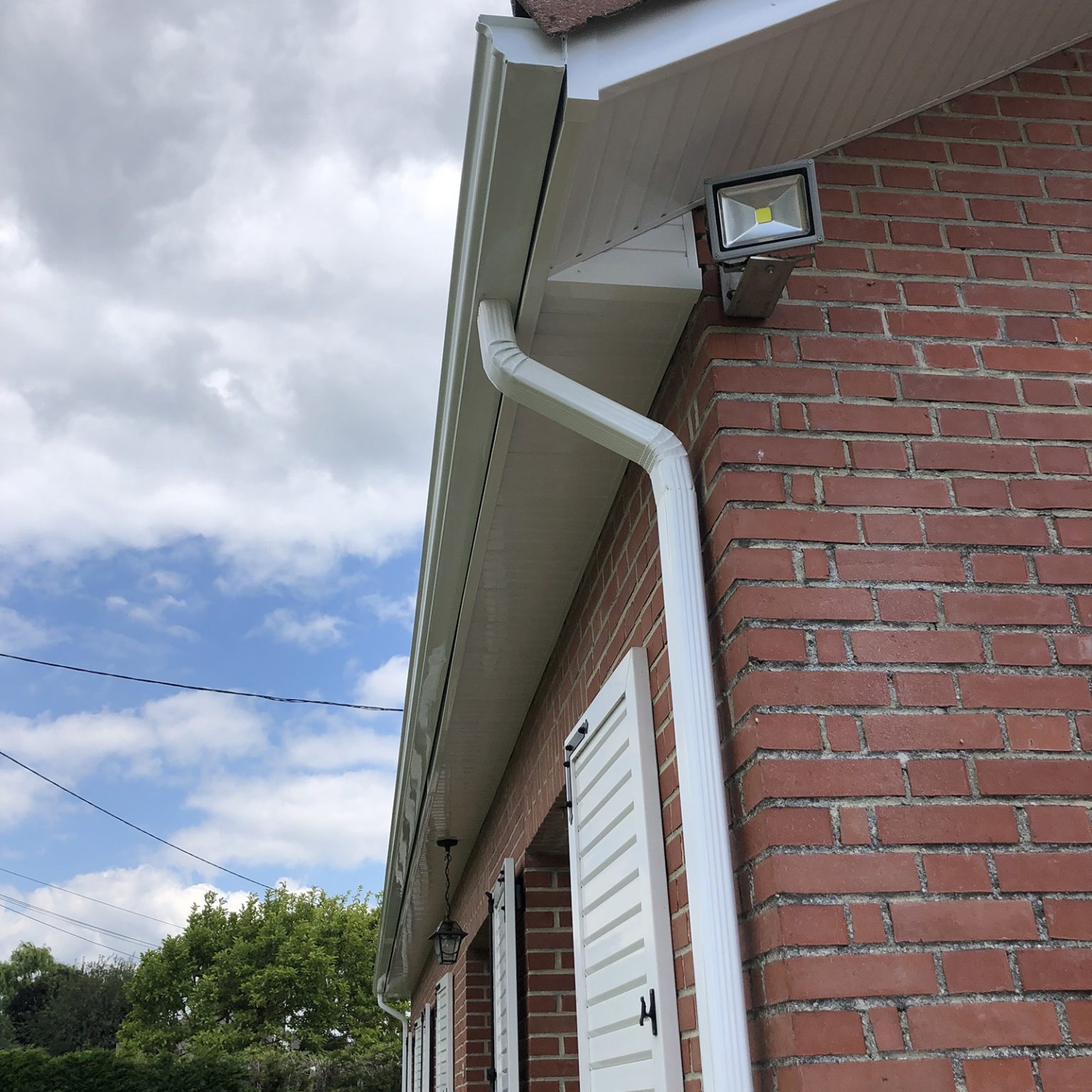 Gouttière PVC blanche neuve avec habillage sous-toiture