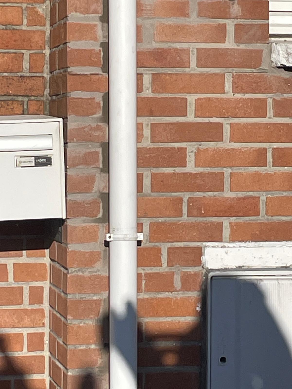 Façade brique avec gouttière et descente PVC blanche